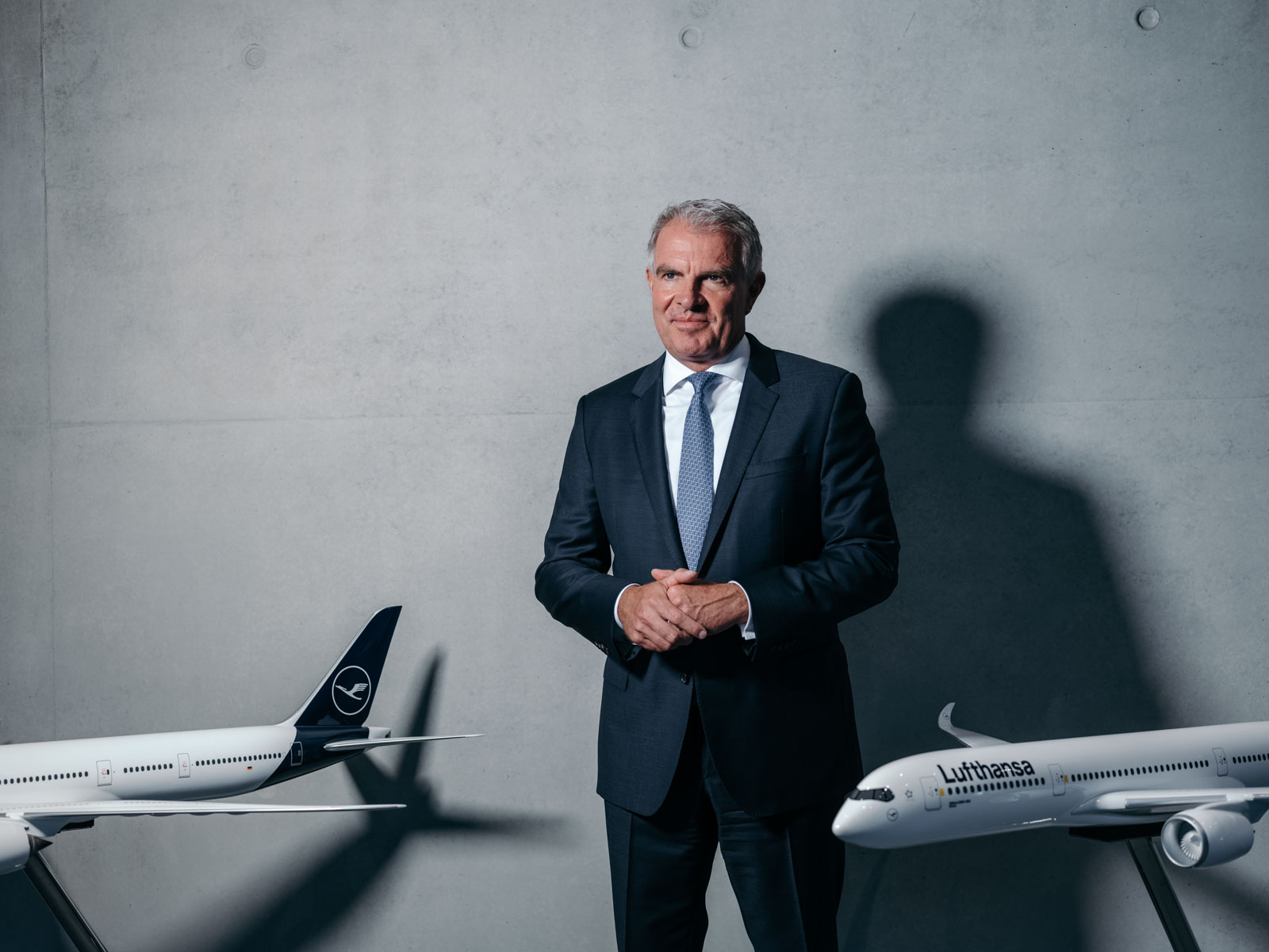 Carsten Spohr ist CEO der Lufthansa AG. Spohr im Portrait am Flughafen Frankfurt zwischen zwei Flugzeugmodellen, 2022