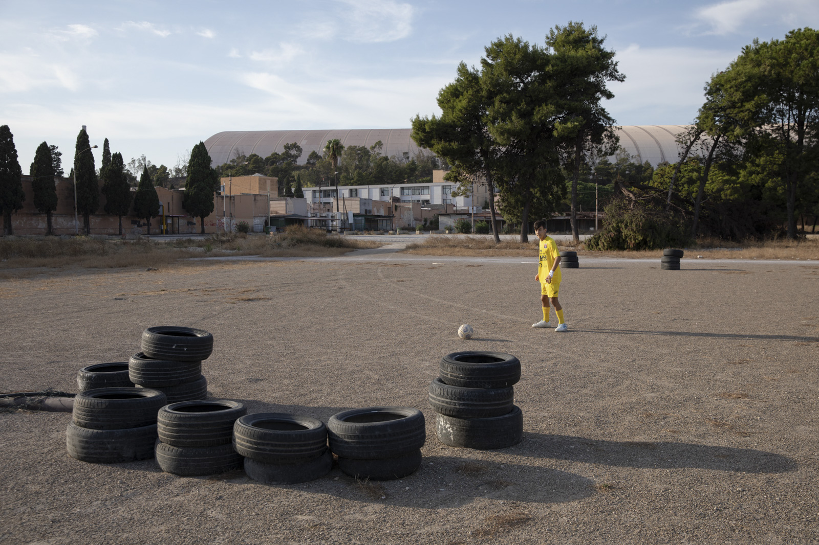 Antonio, 15, spielt im Stadtteil Tamburi auf einem verwaisten Platz Fußball. Die Stadtverwaltung rät auf Grund der anhaltenden Emissionen durch das Stahlwerk offiziell davon ab, im freien Sport zu treiben. September, 2023